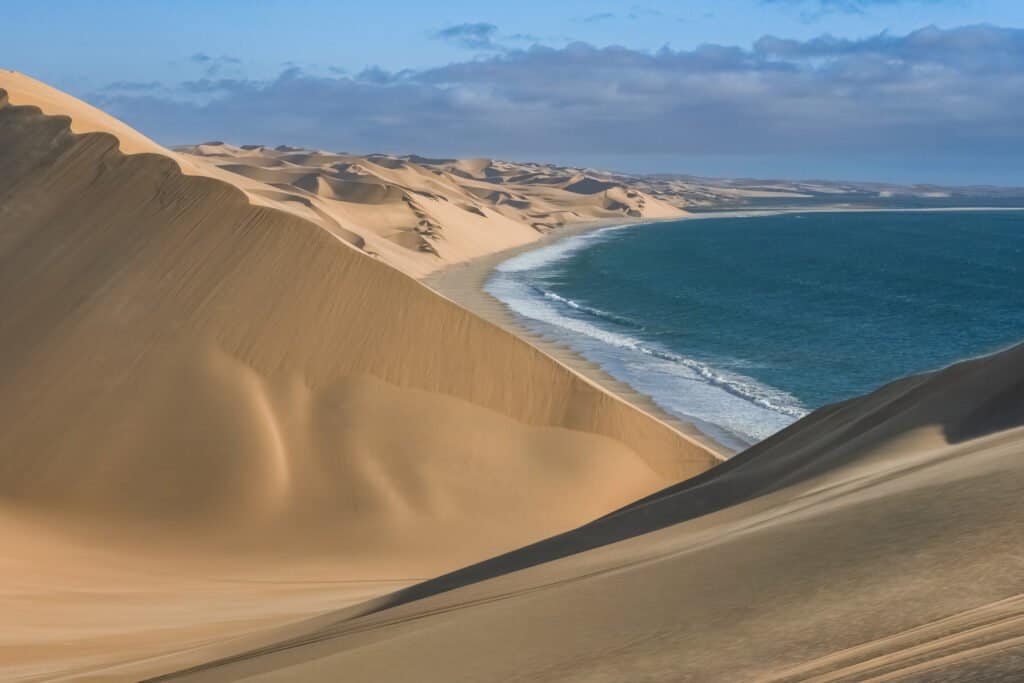 Namibia, the Namib desert, landscape of yellow dunes falling into the sea