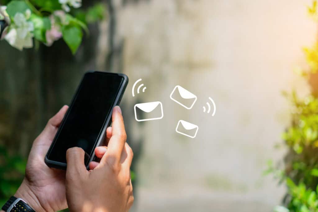 Woman hand using smartphone and it's show email receive notification icon pop up on screen of mobile phone. 
