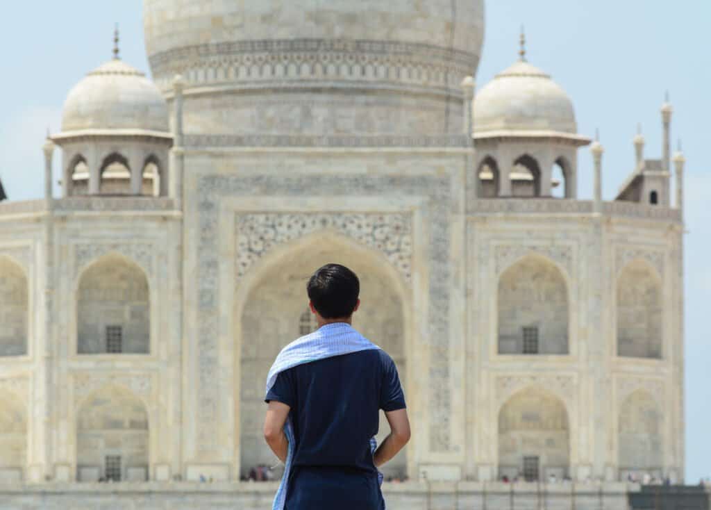 A man looking at the Taj Mahal in Agra, India.