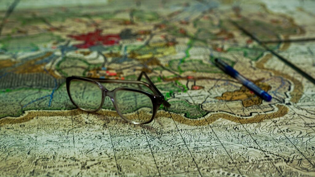 a pair of glasses sitting on top of a map