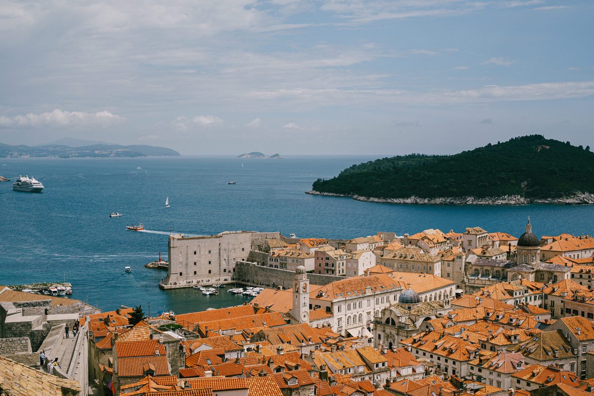 Dubrovnik's old town roofs and the old harbour seen from the city walls, with Lokrum island offshore