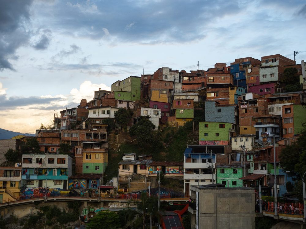 Painted brick houses stacked up the Comuna 13 hillside in Medellin at dusk
