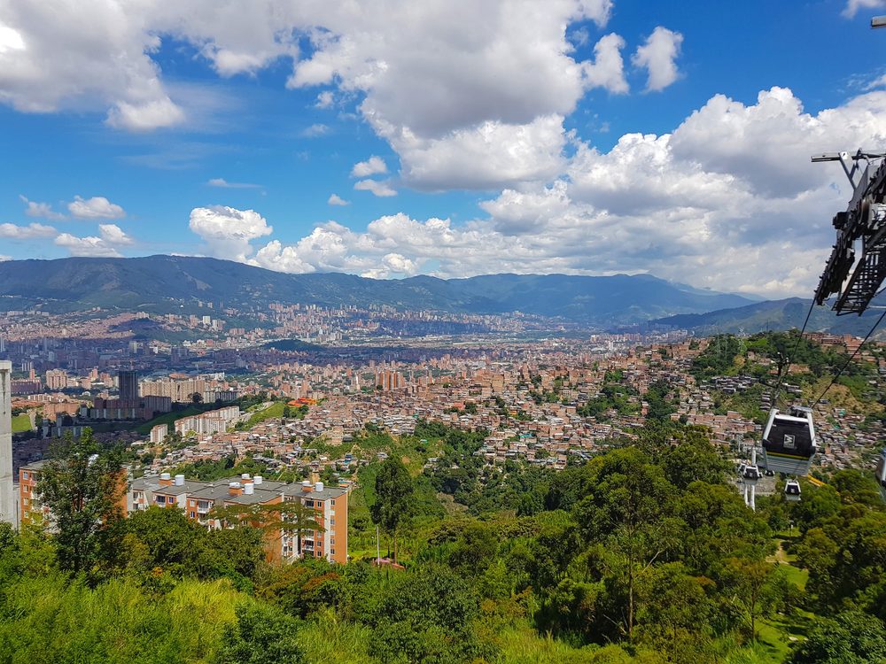 A Metrocable gondola above Medellin, with the city filling the valley and mountains behind