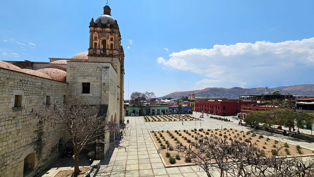 The Santo Domingo church and convent in Oaxaca above its plaza, with the valley hills behind