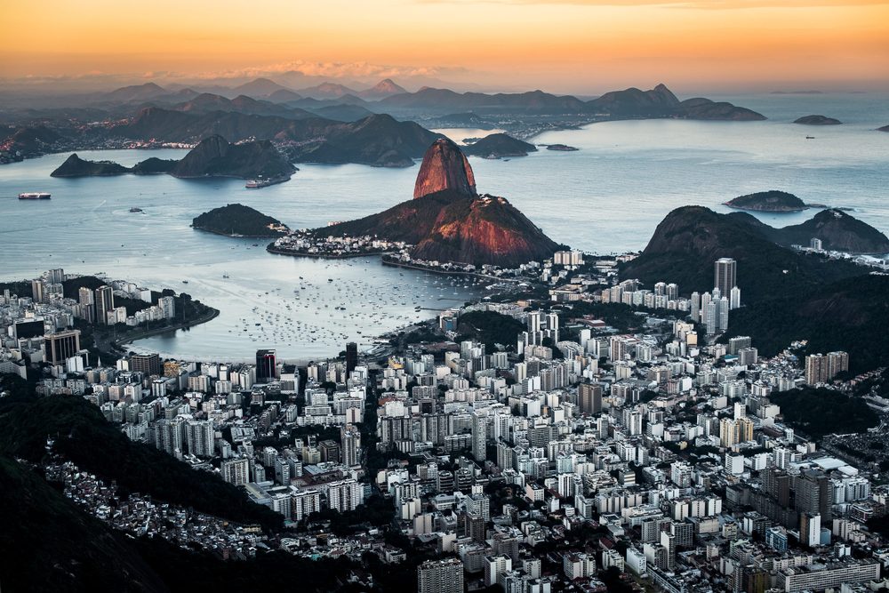 Sugarloaf Mountain lit by sunset above Botafogo bay, with Guanabara Bay and the hills beyond